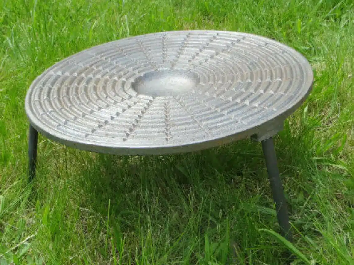 liatinový grilovací plát na nohách určený na varenie nad ohňom