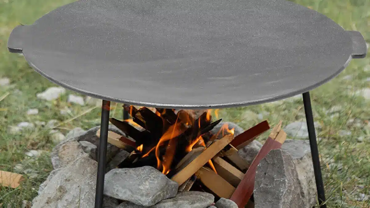 oceľový grilovací plát pripravený nad otvoreným ohňom